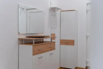 a bathroom with white cabinets and a mirror at Villa Sofija in Ljubljana