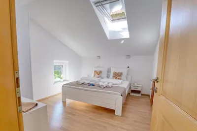 a bedroom with a bed in a room with a skylight at Hisa idej in Sežana