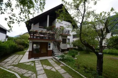 a house with a balcony and a tree at Apartment House Anton with free parking in Bovec