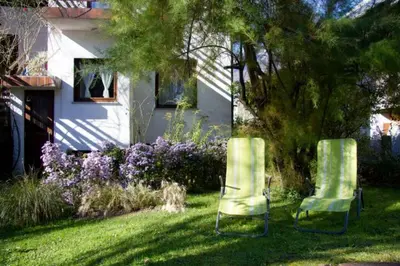 two chairs sitting in the grass in front of a house at Apartment House Anton with free parking in Bovec