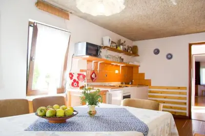 a kitchen with a table with a bowl of fruit on it at Apartment House Anton with free parking in Bovec