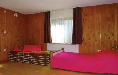 a bedroom with a pink bed and a window at Apartment House Anton with free parking in Bovec