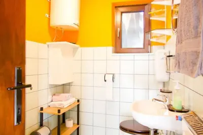 a bathroom with a white sink and a yellow wall at Apartment House Anton with free parking in Bovec