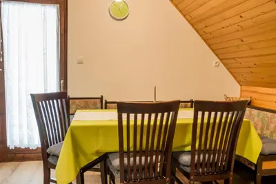 a dining room with a yellow table and chairs at Apartments Štros in Bohinj