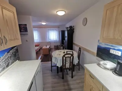 a kitchen and dining room with a table and chairs at Apartments Štros in Bohinj