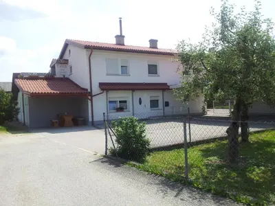 a white house with a fence in front of it at Guest House Tara in Moravske Toplice