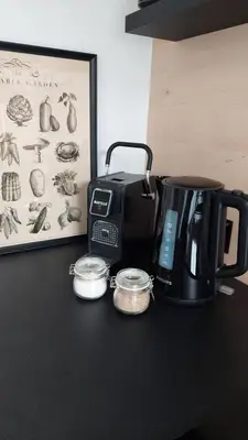 a black counter with a coffee maker and a toaster at HERBALIJA Apartment Amalija - in the embrace of wellbeing in Podčetrtek