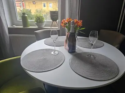 a white table with two glasses and a bottle of wine at Apartma Pekrska vila in Limbuš