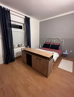 a bedroom with a bed with a large wooden table at Apartma Pekrska vila in Limbuš