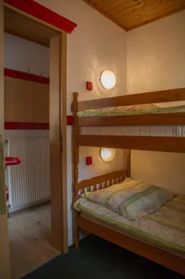 a bedroom with two bunk beds and a doorway at Apartments & Rooms Smučka in Kranjska Gora