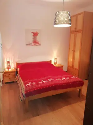 a bedroom with a red bed with two night stands at Apartments & Rooms Smučka in Kranjska Gora