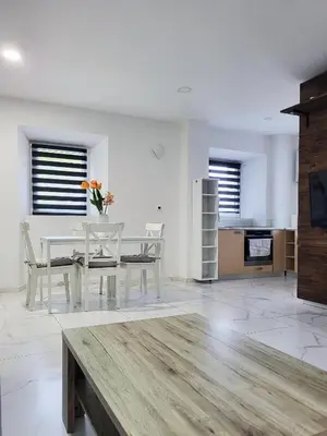 a dining room with a table and chairs and a kitchen at Stara Pošta Apartment 1 in Grosuplje