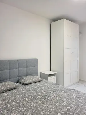 a bedroom with a bed and a white cabinet at Stara Pošta Apartment 1 in Grosuplje