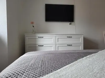 a white dresser with a flat screen tv on a wall at Stara Pošta Apartment 5 in Grosuplje