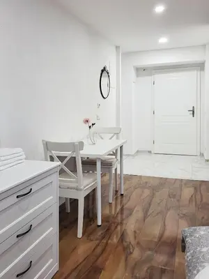 a white dining room with a white table and chairs at Stara Pošta Apartment 5 in Grosuplje
