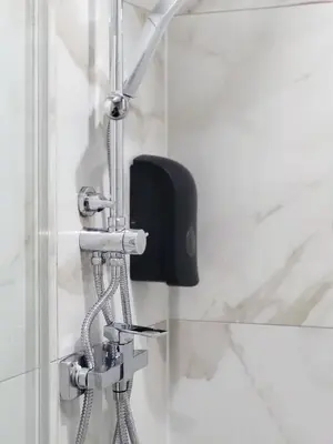 a shower head in a bathroom with a shower chain at Stara Pošta Apartment 5 in Grosuplje