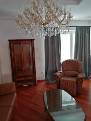 a living room with a chandelier and a table and chairs at Apartma Bistrica in Slovenska Bistrica