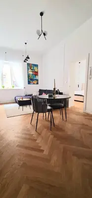 a large living room with a table and chairs at Apartment Tivoli in Ljubljana