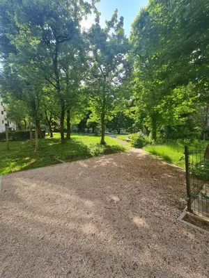 a gravel driveway with trees in a park at Apartment Tivoli in Ljubljana