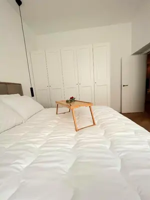 a table sitting on top of a white bed at Apartment Tivoli in Ljubljana