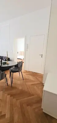 a white room with a table and chairs and a desk at Apartment Tivoli in Ljubljana