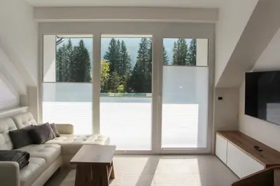 a living room with a couch and a large window at Apartment Simona in Kranjska Gora