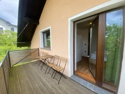 a balcony with two chairs and a table and sliding glass doors at Countryside Apartment Agnes in Šentjošt nad Horjulom