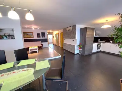 a kitchen and a living room with a table and chairs at Countryside Apartment Agnes in Šentjošt nad Horjulom