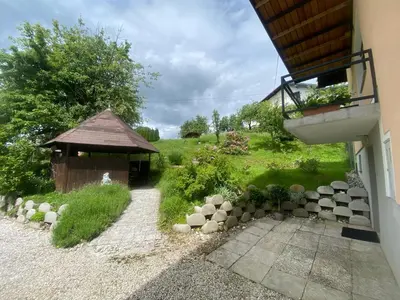a garden with a gazebo next to a building at Countryside Apartment Agnes in Šentjošt nad Horjulom