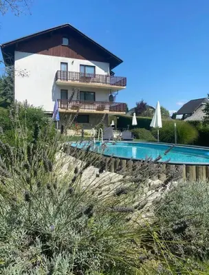 a building with a swimming pool next to a house at Ground Floor Apt with a Pool and Terrace in Pesnica pri Mariboru