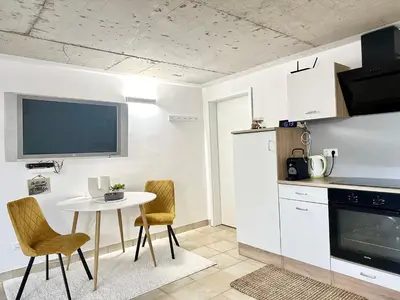 a kitchen with a table and chairs and a table and a tv at Ground Floor Apt with a Pool and Terrace in Pesnica pri Mariboru