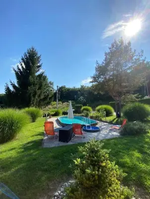 a backyard with a pool with chairs and a table at Ground Floor Apt with a Pool and Terrace in Pesnica pri Mariboru