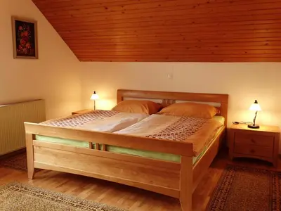 a bedroom with a large wooden bed with two lamps at Garden Apartments Maria in Bled