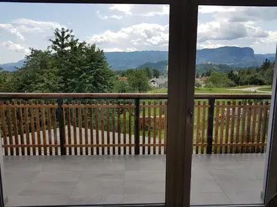 a view from a window of a balcony with mountains at Garden Apartments Maria in Bled