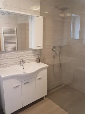 a bathroom with a white sink and a shower at Garden Apartments Maria in Bled