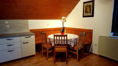 a kitchen with a table and chairs and a table and a counter at Garden Apartments Maria in Bled