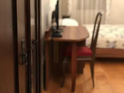 a wooden table with a red chair next to a bedroom at Guesthouse Bistra in Vrhnika