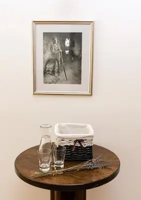 a table with a basket and two glasses and a picture at Guesthouse Bistra in Vrhnika