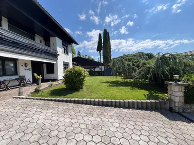 a patio in front of a building with a yard at Sara`s Guesthouse Bled in Bled