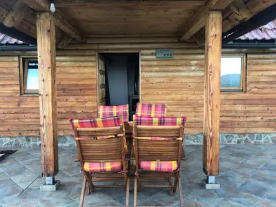 a group of chairs sitting on the porch of a cabin at Vineyard Cottage Janko & Metka in Otočec