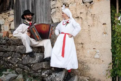a man and a woman standing next to a man playing an accordion at Vineyard Cottage Brodaric in Metlika