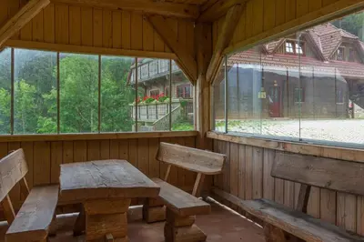 an empty room with a wooden table and benches at Apartments Petek in Gornji Grad