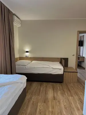 a hotel room with two beds and a mirror at Hotel Roškar in Ptuj