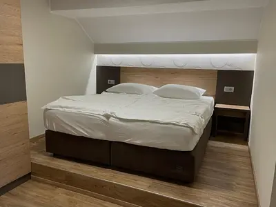 a bed with white sheets and pillows in a bedroom at Hotel Roškar in Ptuj