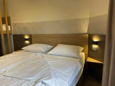 a large white bed with two pillows on it at Hotel Roškar in Ptuj