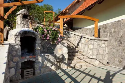 a stone oven with flowers on a wall at Vineyard Cottage Lustek in Novo Mesto