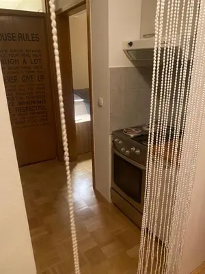 a kitchen with a stove and a door to a room at Apartment La Vie in Maribor