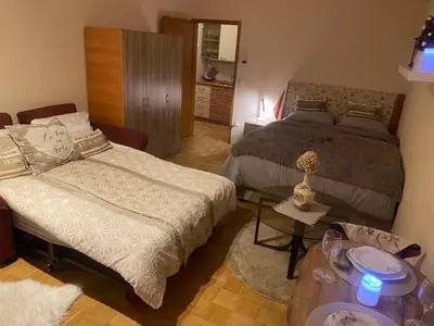 a bedroom with a bed and a couch and a table at Apartment La Vie in Maribor