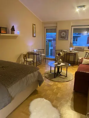 a bedroom with a bed and a living room with tables at Apartment La Vie in Maribor