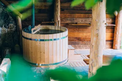 a wooden tub in a wooden building with water at Vineyard Cottage Rataj 1 in Novo Mesto